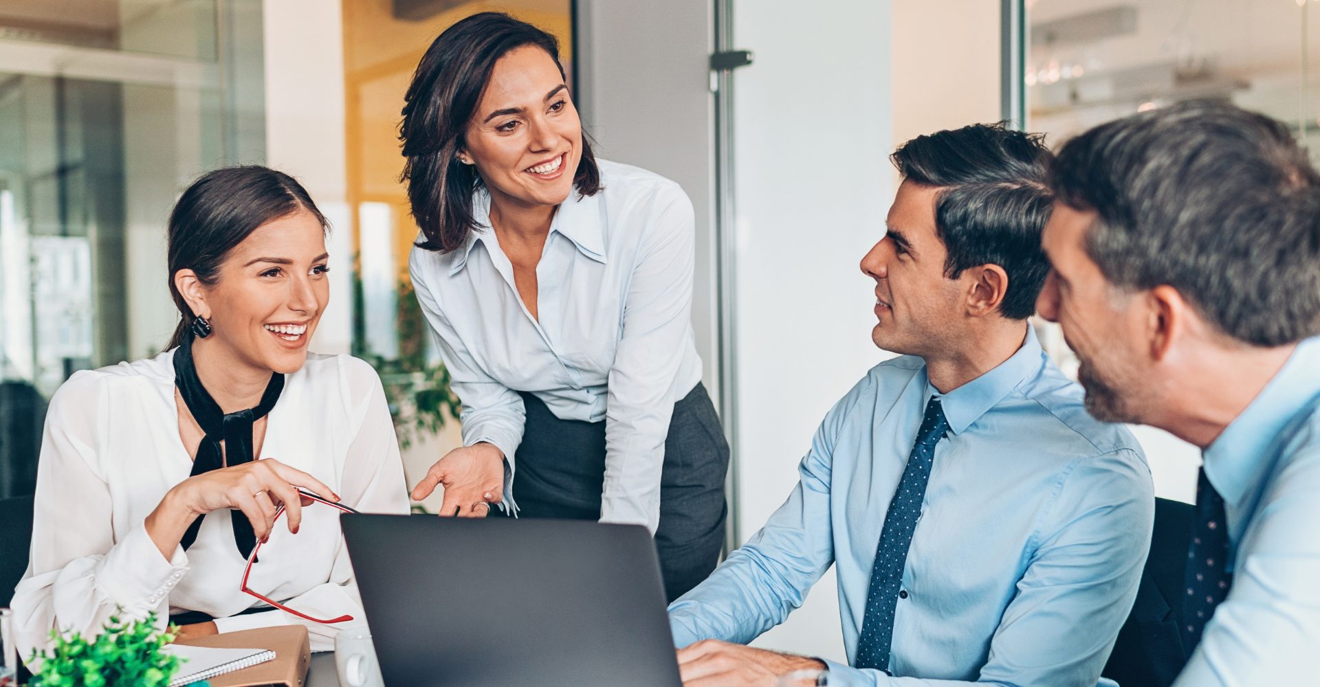 The Intentional Leader_Coaching Page A woman leading a meeting with four team members applauding